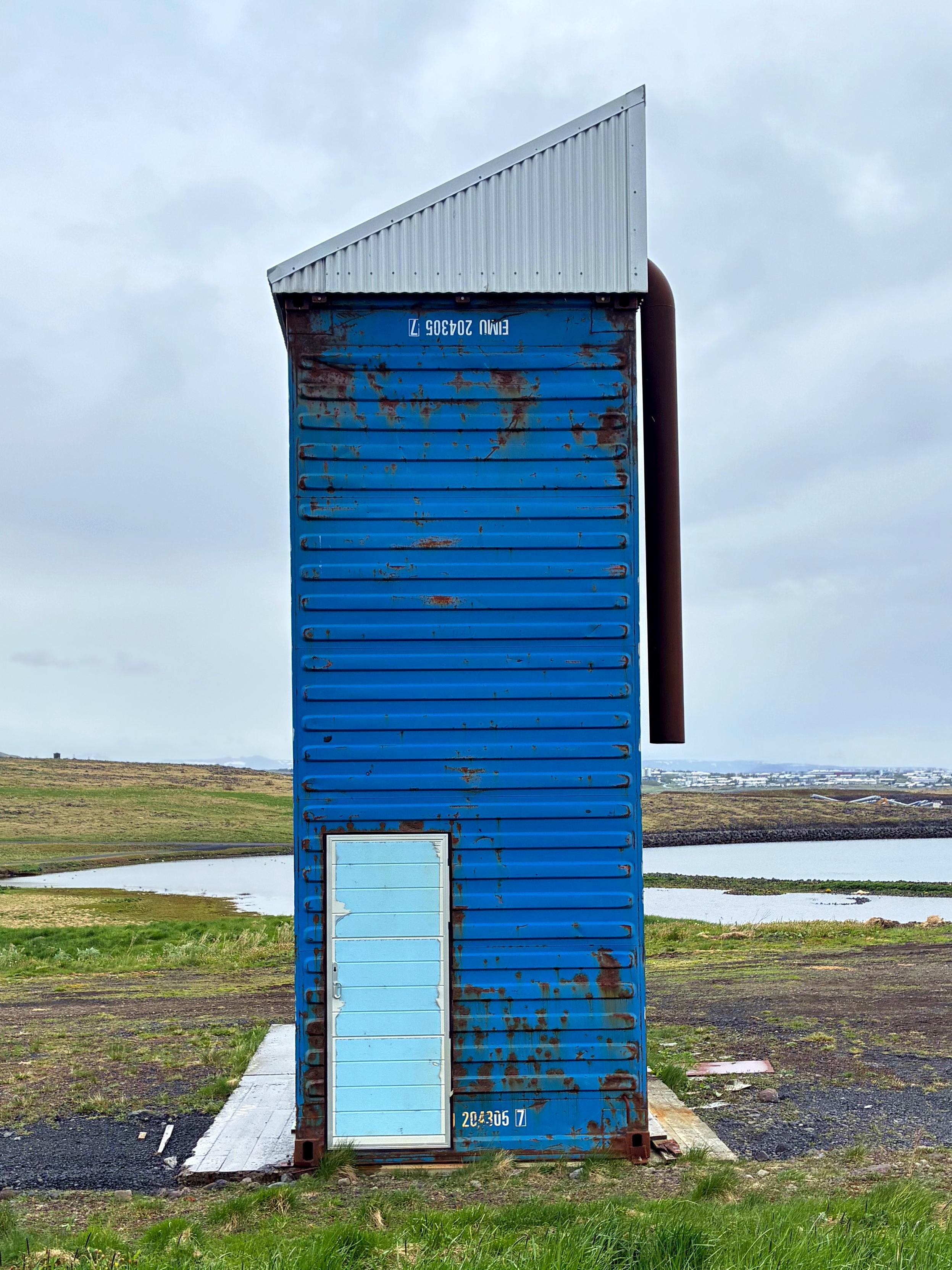 A strange blue tower with a light blue door.