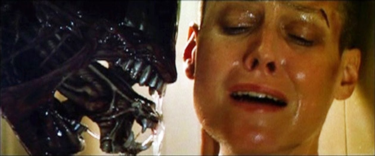 Still-frame from ALIEN 3, the xenomorph snarls and extends its inner jaws, closely examining a terrified Ripley