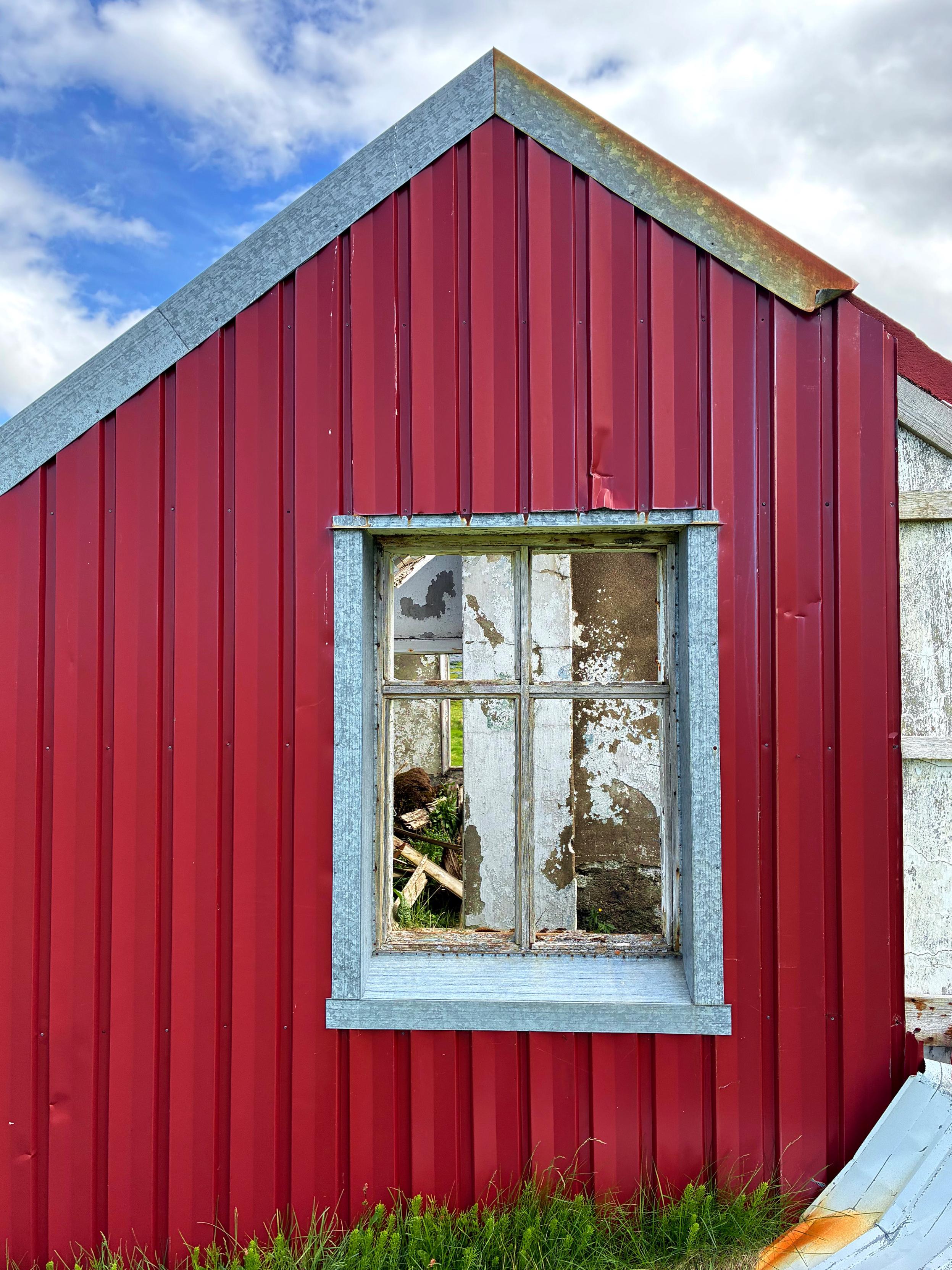 A window on an abandoned red house.