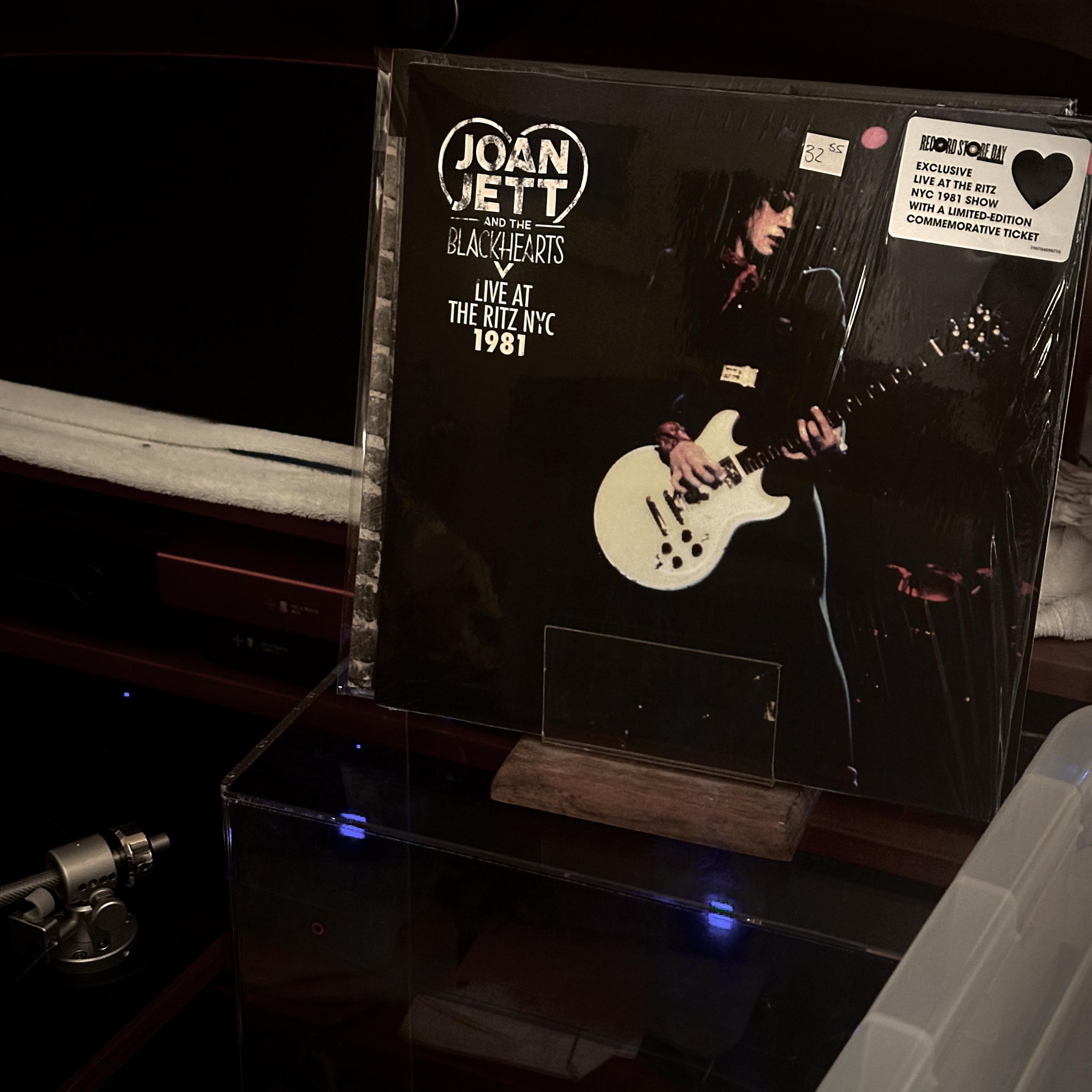 My Now Playing prop with the Joan Jett and the Blackhearts Live at the Ritz 1981 record sleeve. It has their Heart logo in the upper left, and a hype sticker in the upper right. The cover is mostly a pic of Joan rocking out with her white guitar at the microphone.
