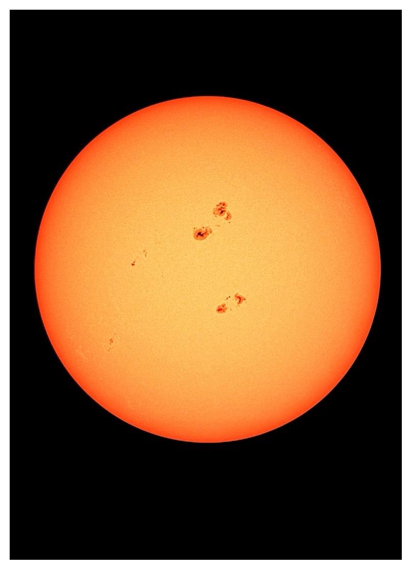 Image of the sun as a large orange-yellow sphere floating in black space, captured with a Dwarf 3 smart telescope with solar filter. A prominent grouping of two sunspot clusters is visible on the upper hemisphere, while a smaller group of clusters is visible on the lower half; these are Active Regions (AR) 4478 and 4479, respectively. A few other individual sunspots dot the surface like freckles. Captured from Brooklyn, NY at 10:26am. Further edited in Snapseed to enhance sunspot contrast. I wasn’t sure if the Dwarf telescope inverted solar images, so I made the decision to rotate the photo 180°. Any suggestions to further correct the orientation are welcome.
