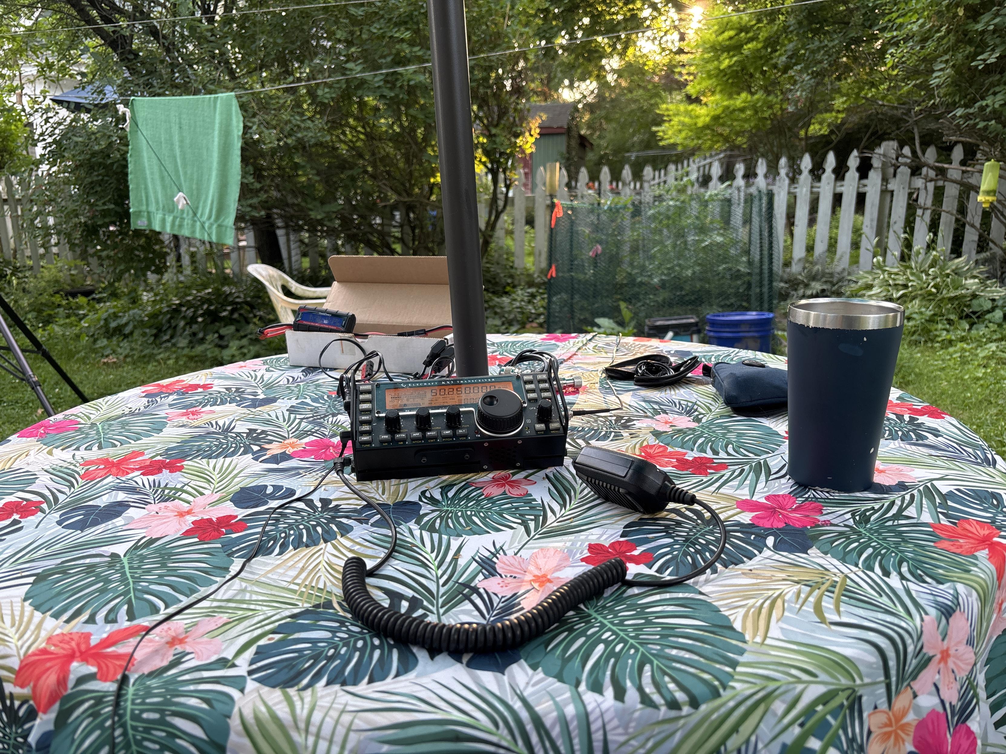 amateur radio transceiver, battery, etc on table in back yard