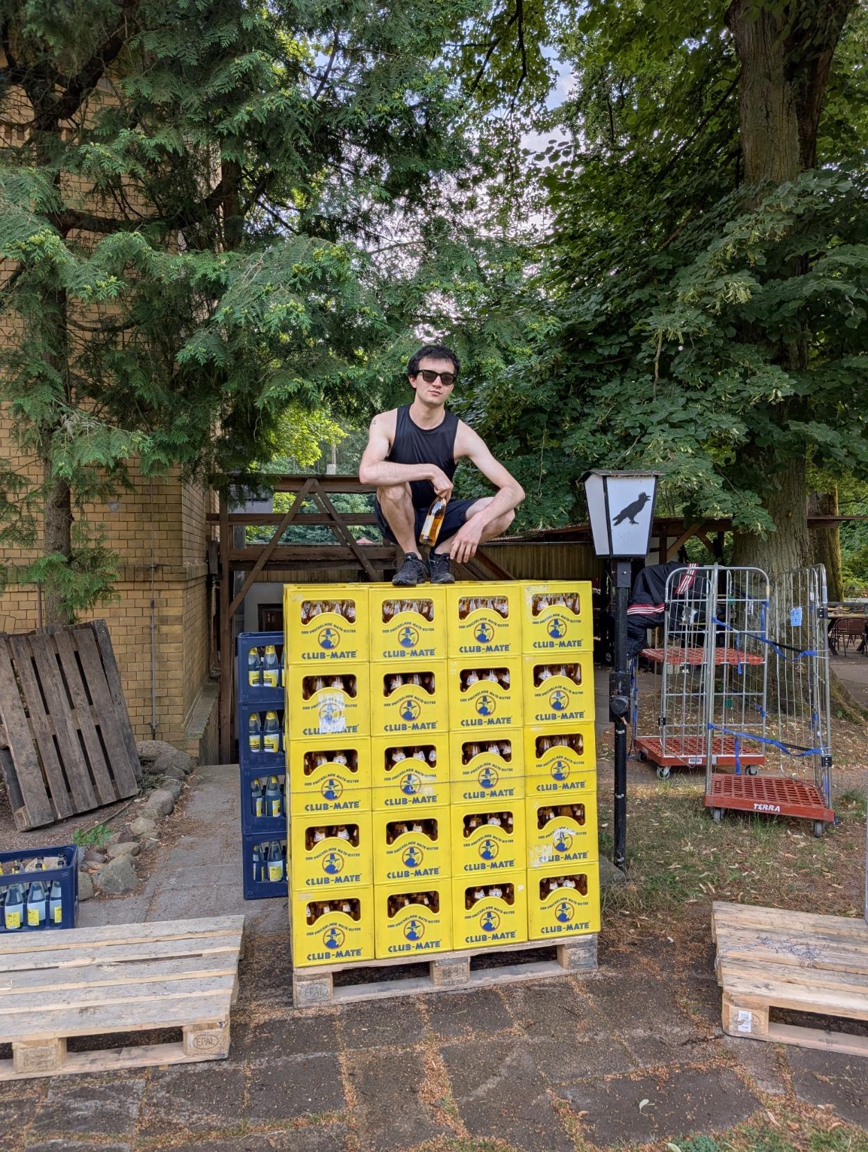 Me squatting over a pallet of Club Mates