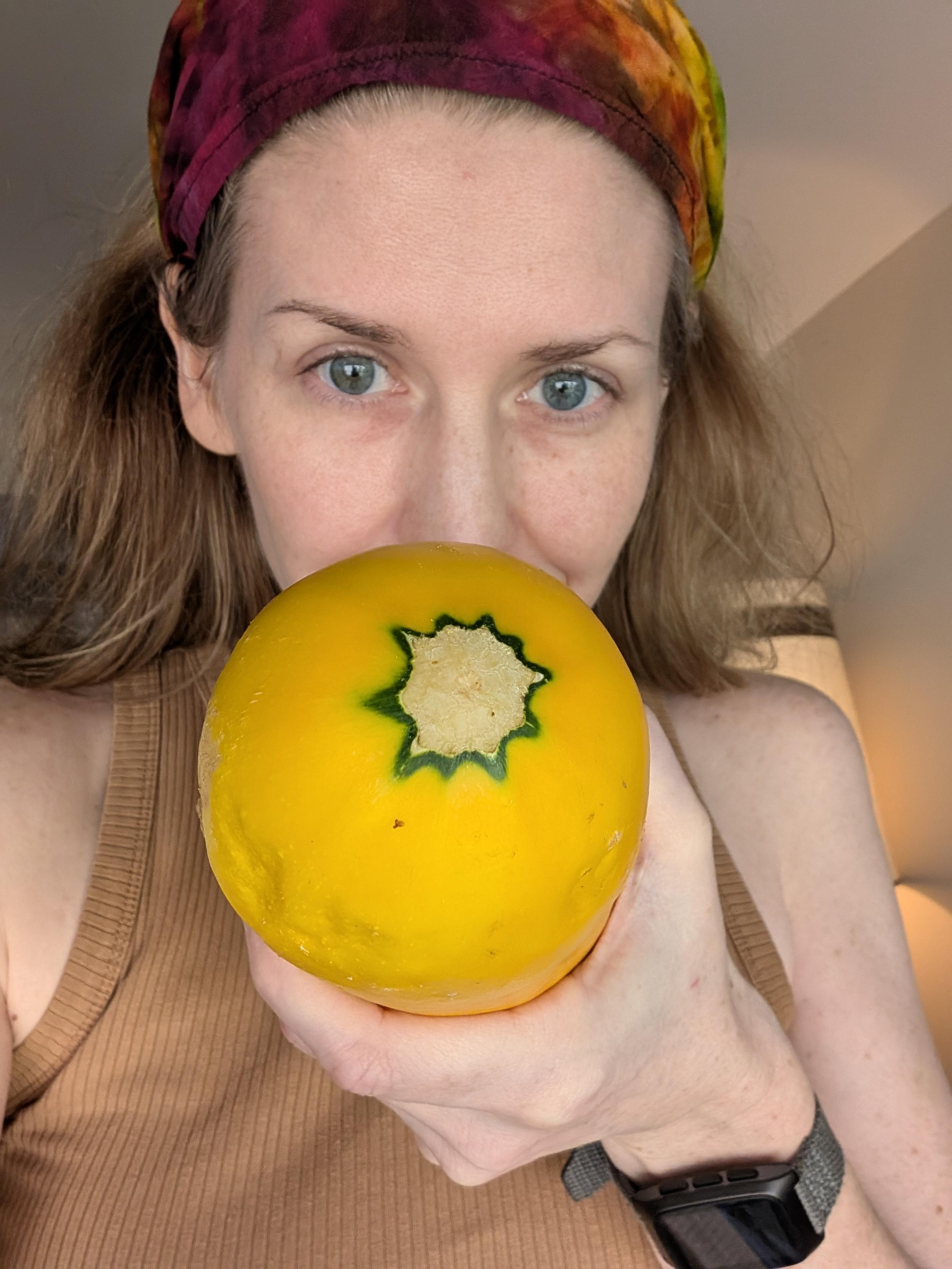 a person holds the flowering end of an obscenely large squash at you while looking at you dead in the eye