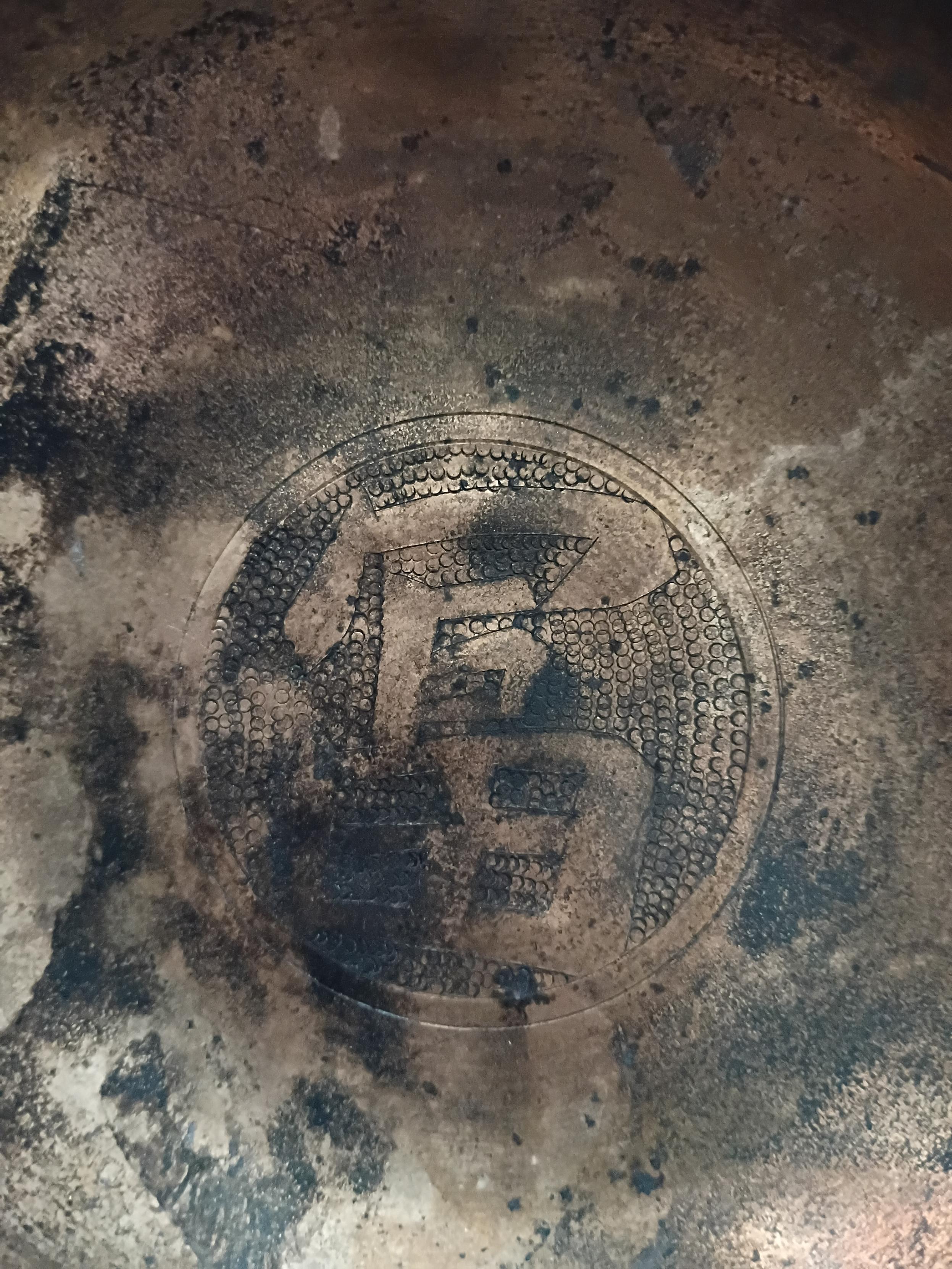 A badly soot stained bowl with the same character embossed into the bottom