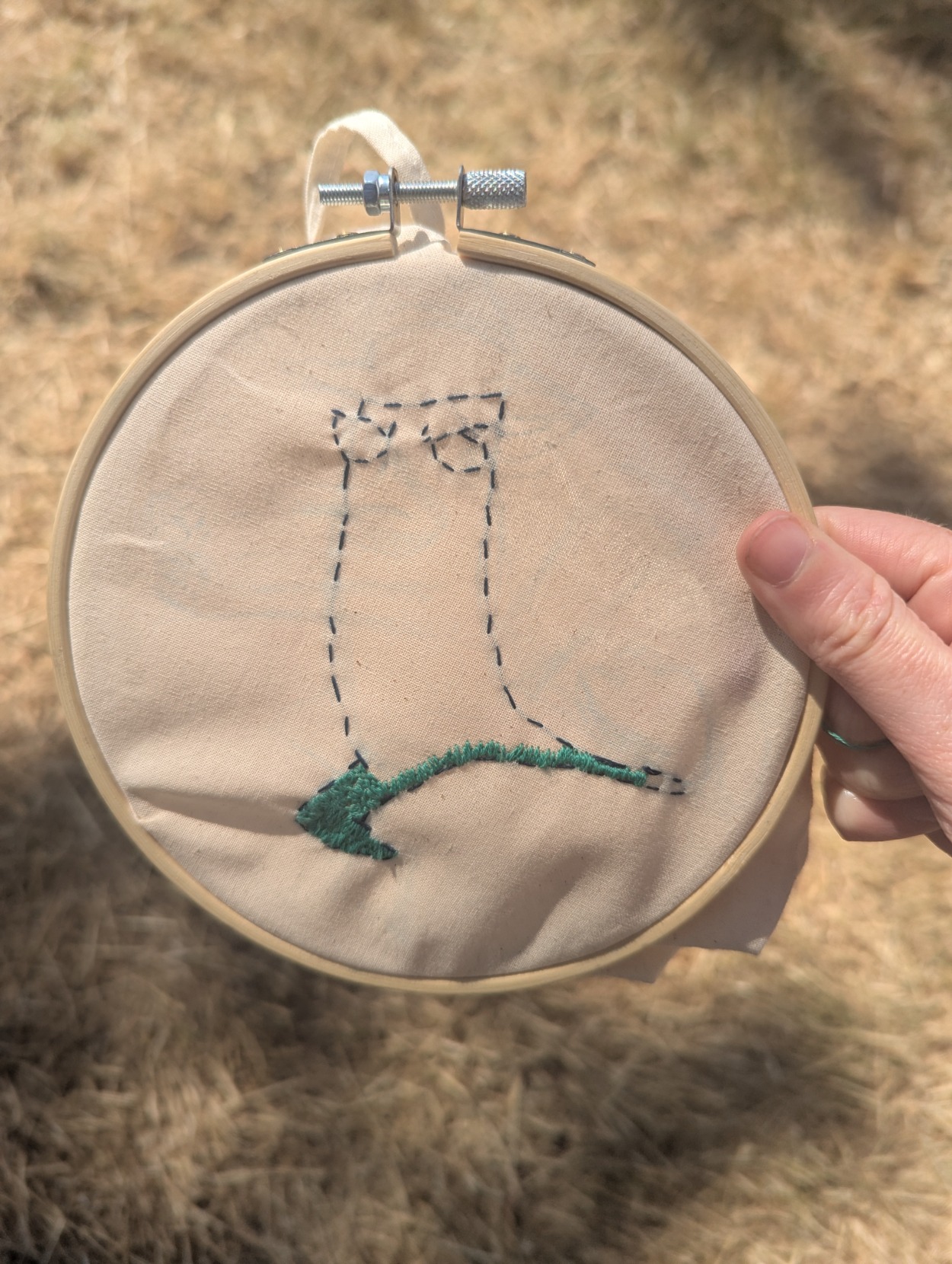 An unfinished embroidery project with an outline of a character that is slowly being filled in with teal.  (Yes, that's Perry the Platypus)