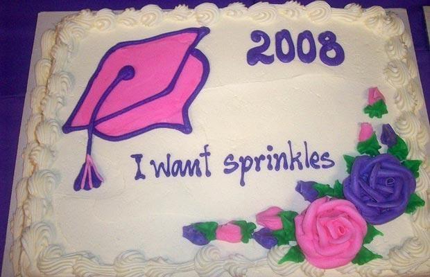 A sheet cake with white frosting, decorated with a purple graduation cap, the year "2008", some pink and purple flowers, and the text "I want sprinkles" written in the center
