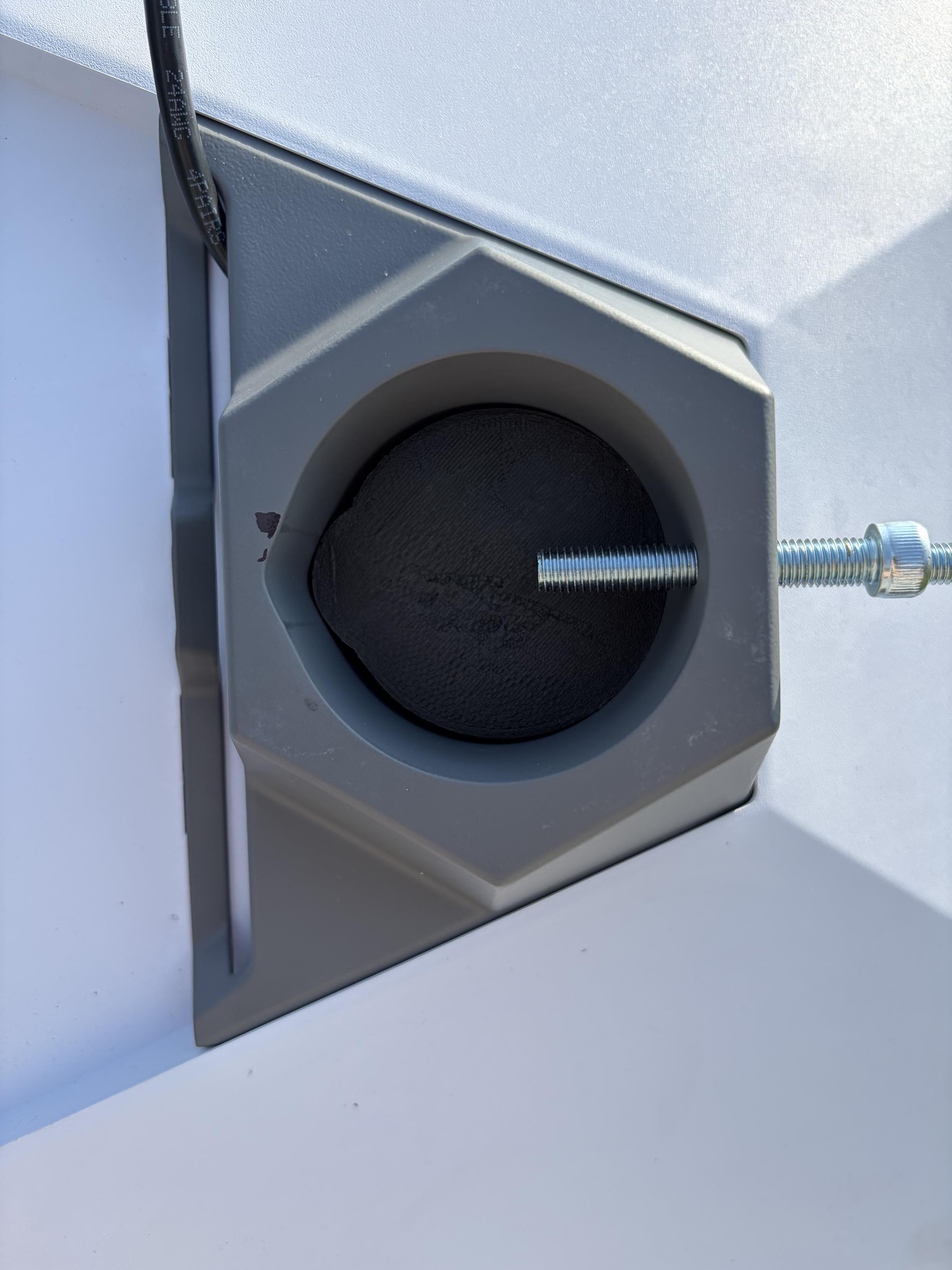 Photograph of my 3d printed wedge resting diagonally in the bottom of the Starlink pole mount adapter because the shape doesn’t match exactly.