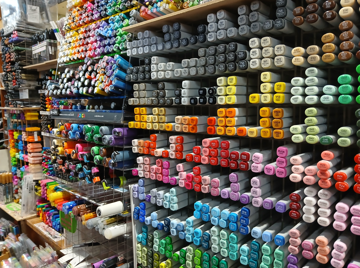 It is the pens section of the art shop. All the markers and pens tucked into their special shelves, in all the colours. Coptic markers nearest the camera and posca paint pens further away. The colours are glorious.