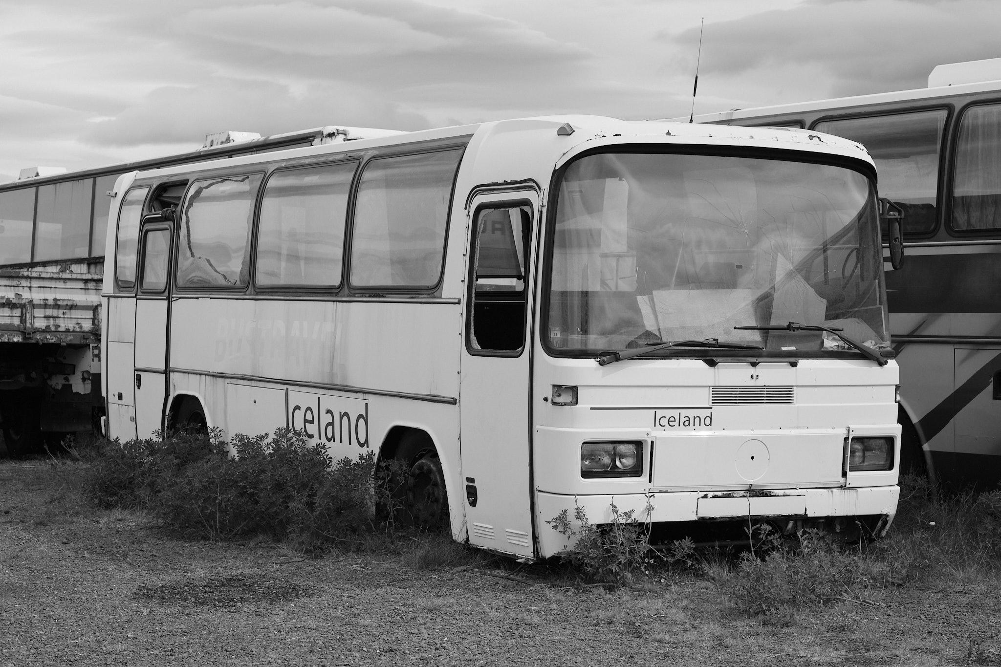 A broken-down tour bus photographed in black and white.