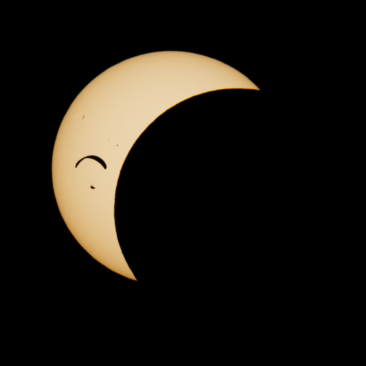 Partial solar eclipse with a paraglider transit.