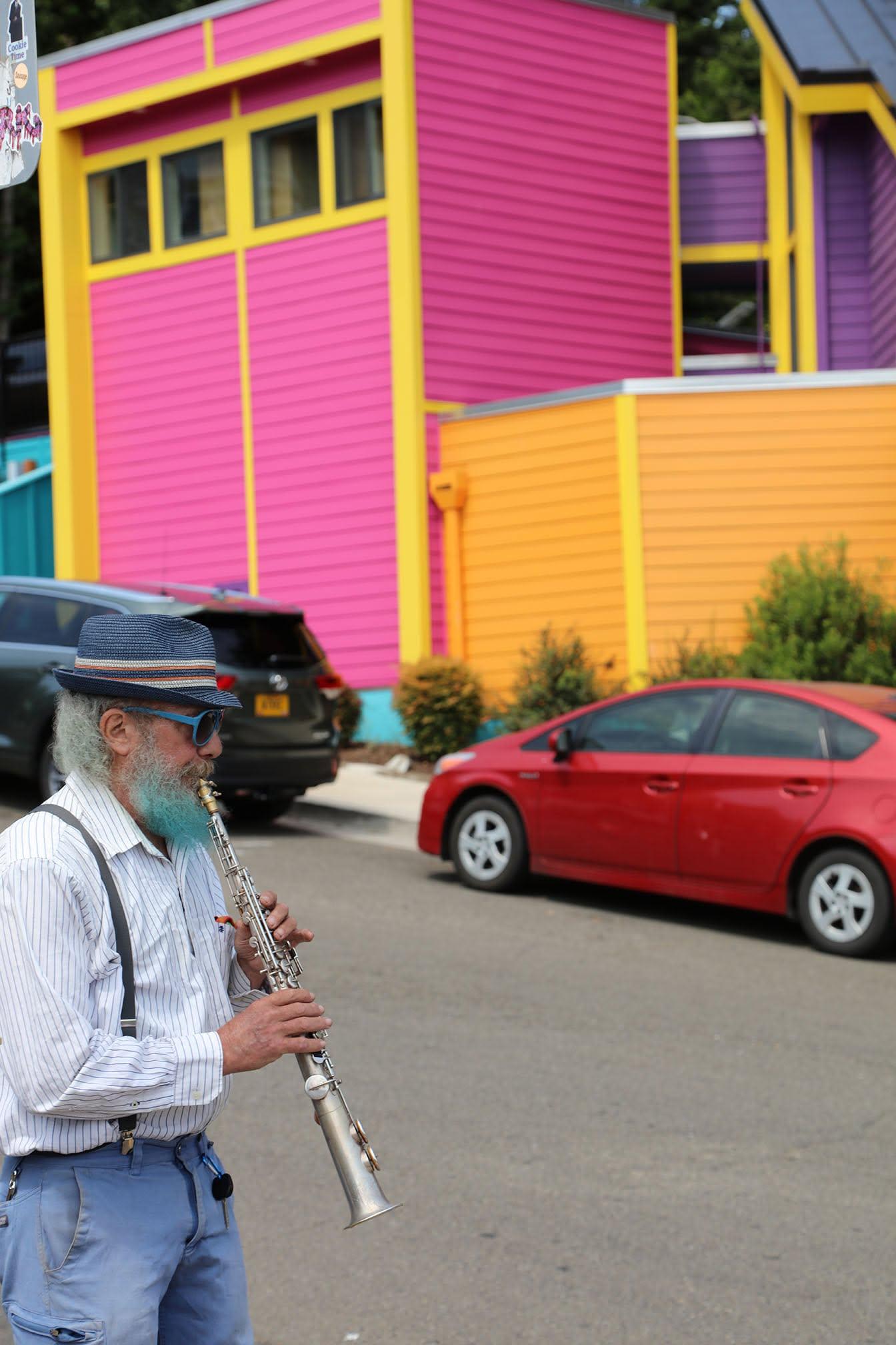 A street musician plays in front of the most brightly-colored house I've ever seen. :)