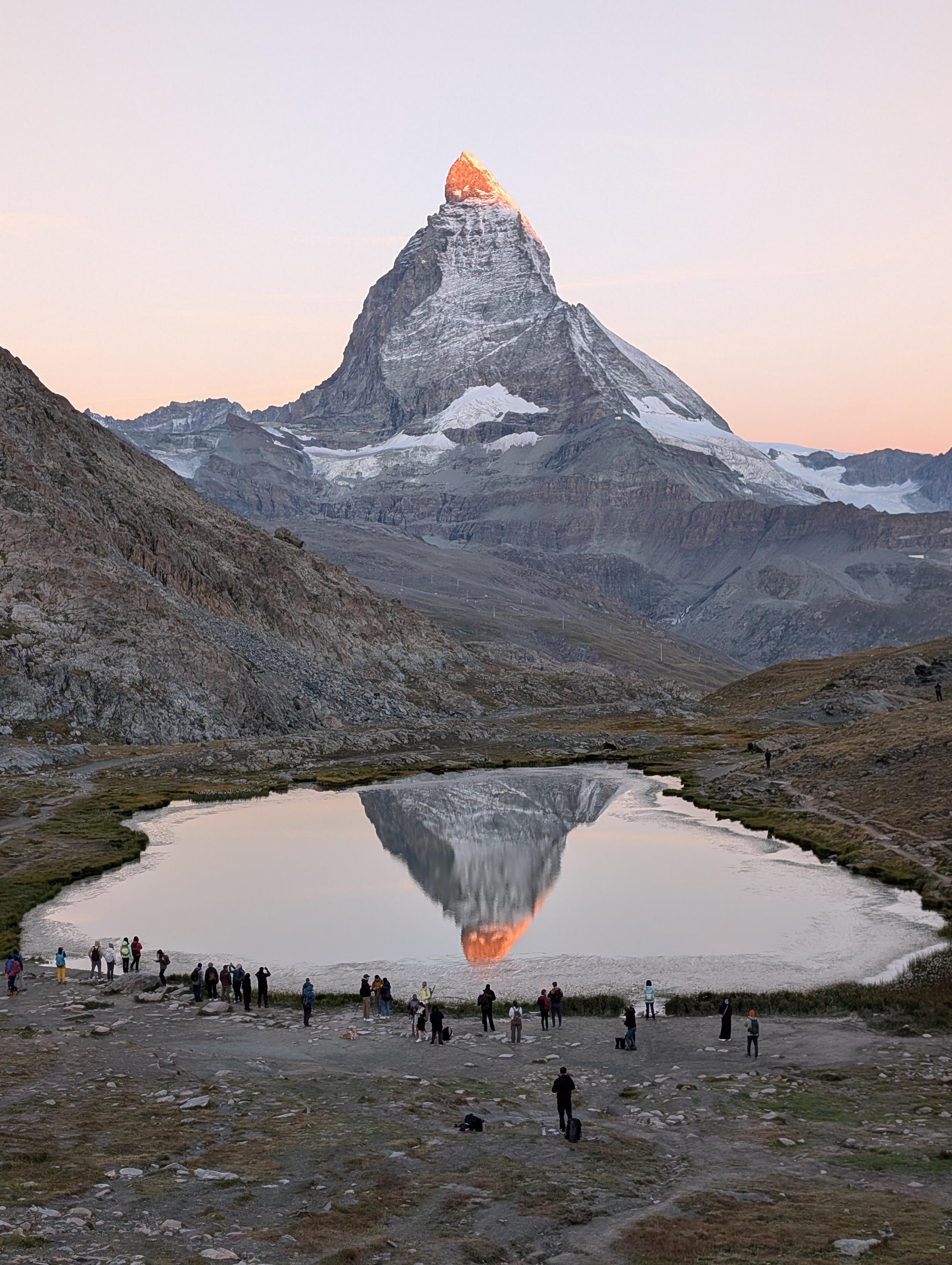 A view of the Matterhorn at sunrise - the top is glowing red, and it is reflecting in a small lake below. Spectacular.