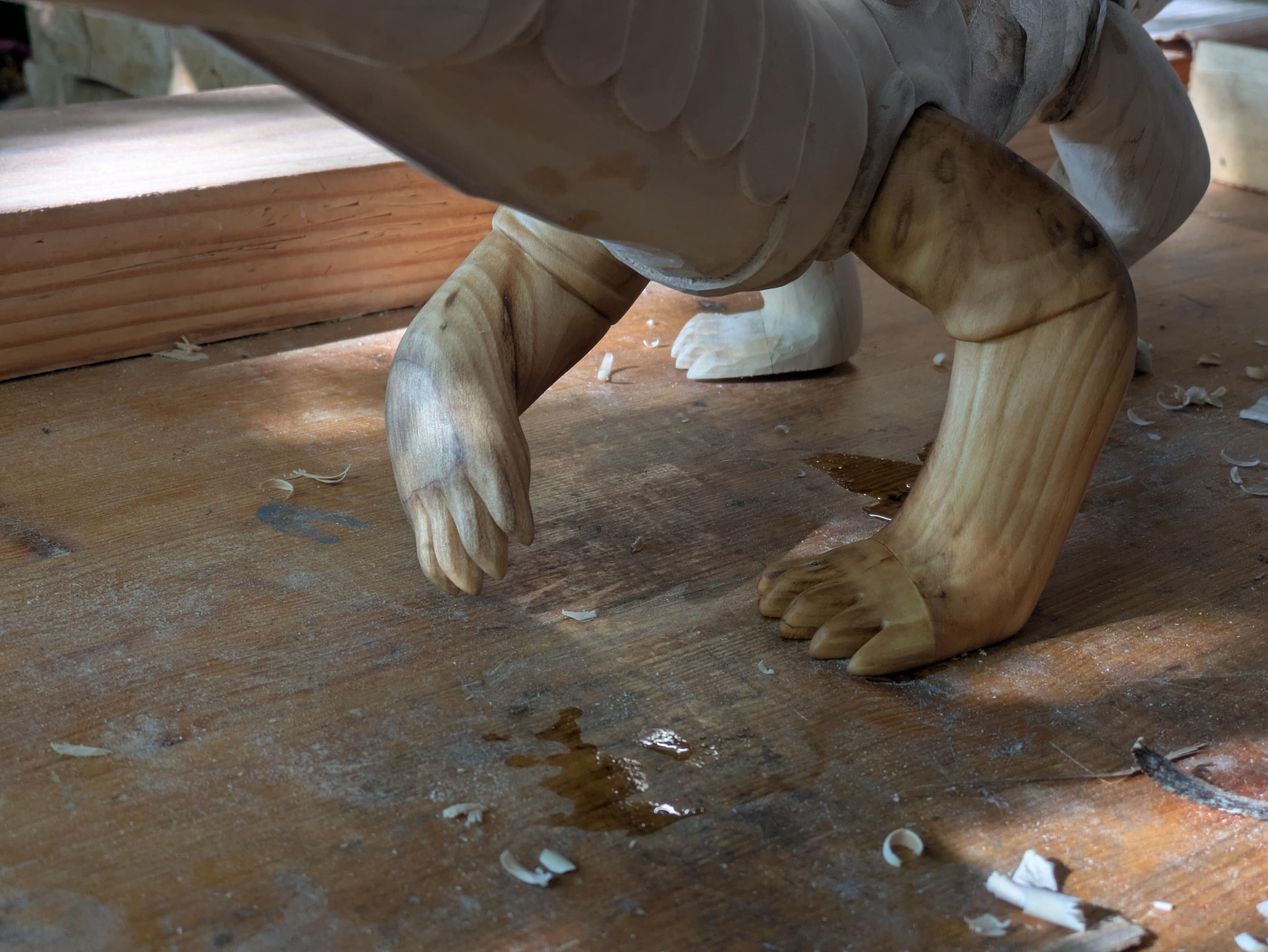 Draft of a woodcarved dragon, focus on the front legs, sanded and oiled