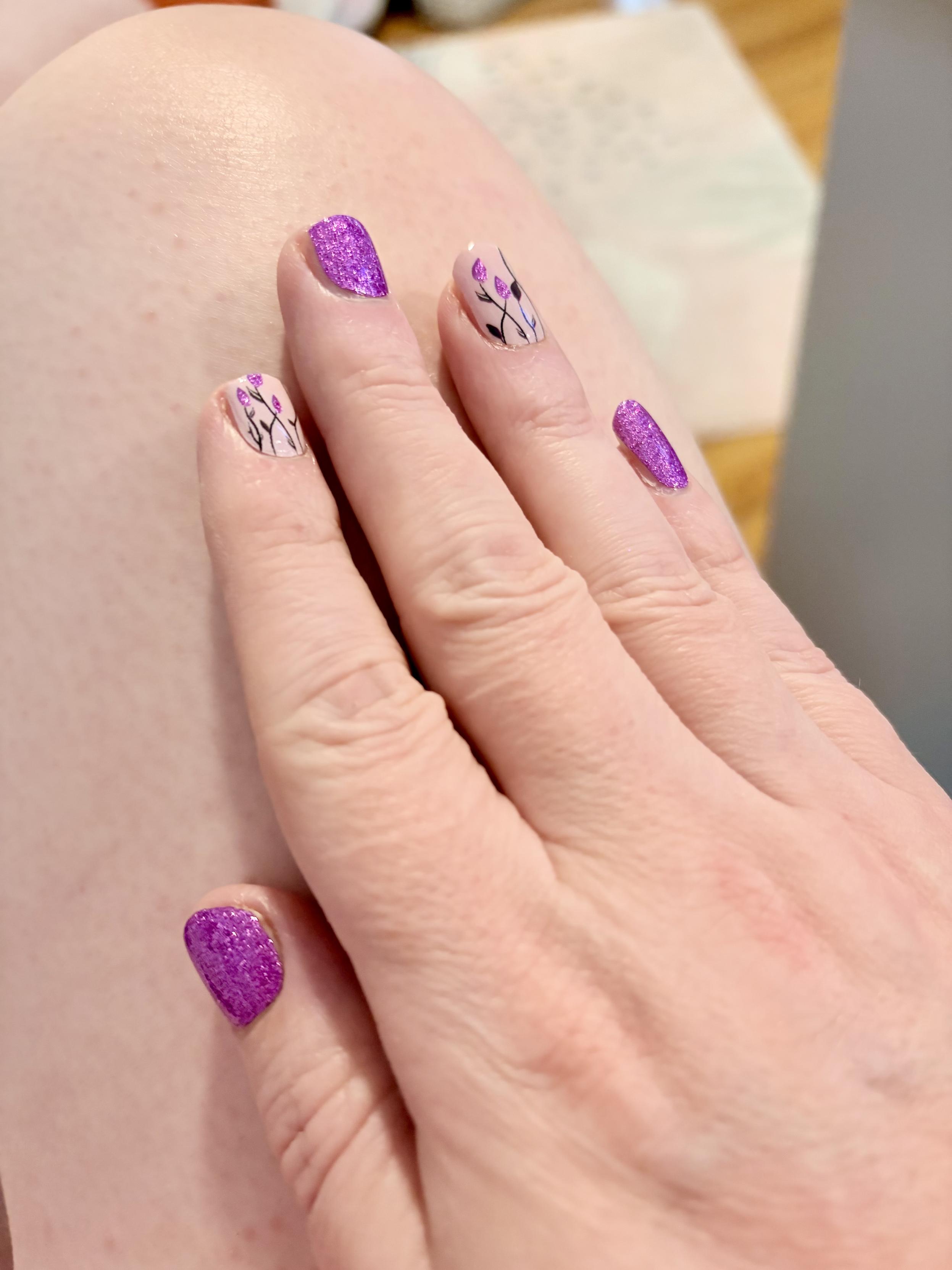 Fresh nails on 7/28/26, alternating purple sparkles and purple tulips on a pink background.
