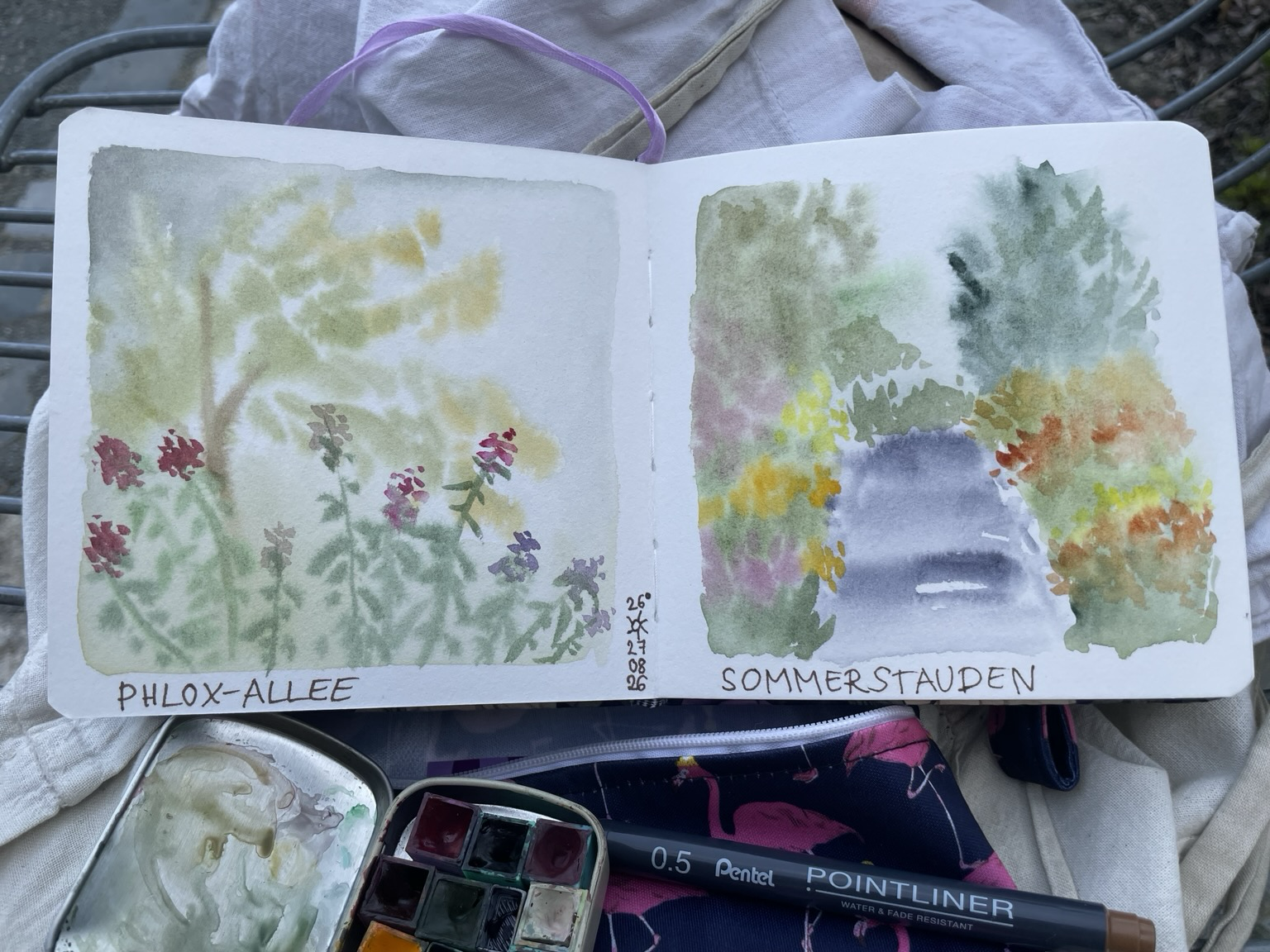 Ein Skizzenbuch mit zwei Aquarellen von sommerlichen Pflanzen und Stauden im botanischen Garten