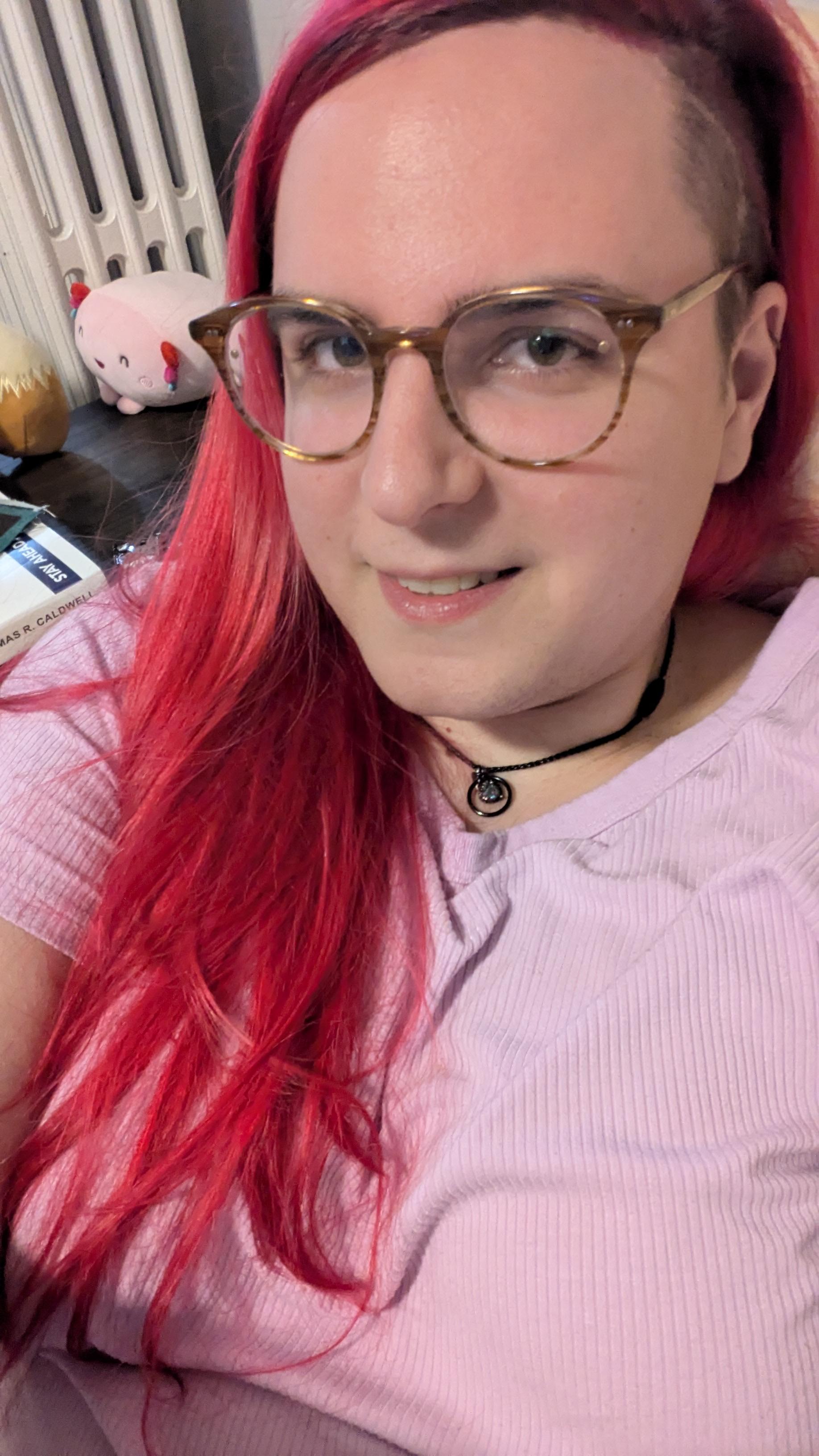 girl wearing glasses with a side shave and vivid long pink hair
