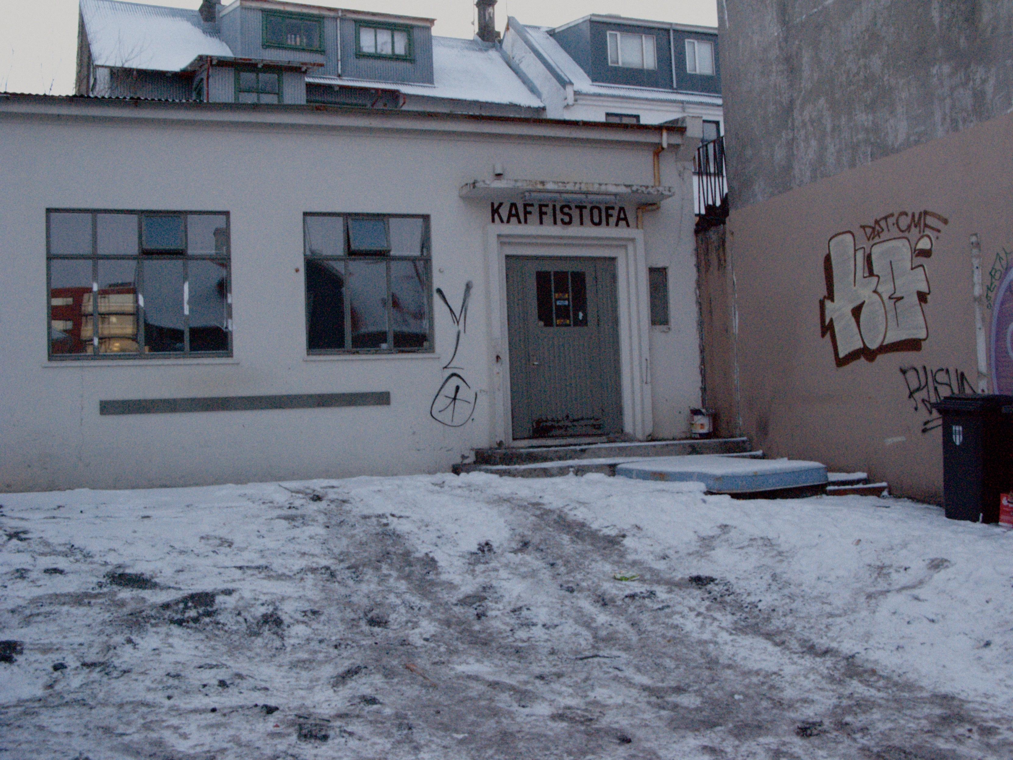 A unobtrusive place with a simple sign, "Kaffistofa". The walls have been tagged with graffiti.
