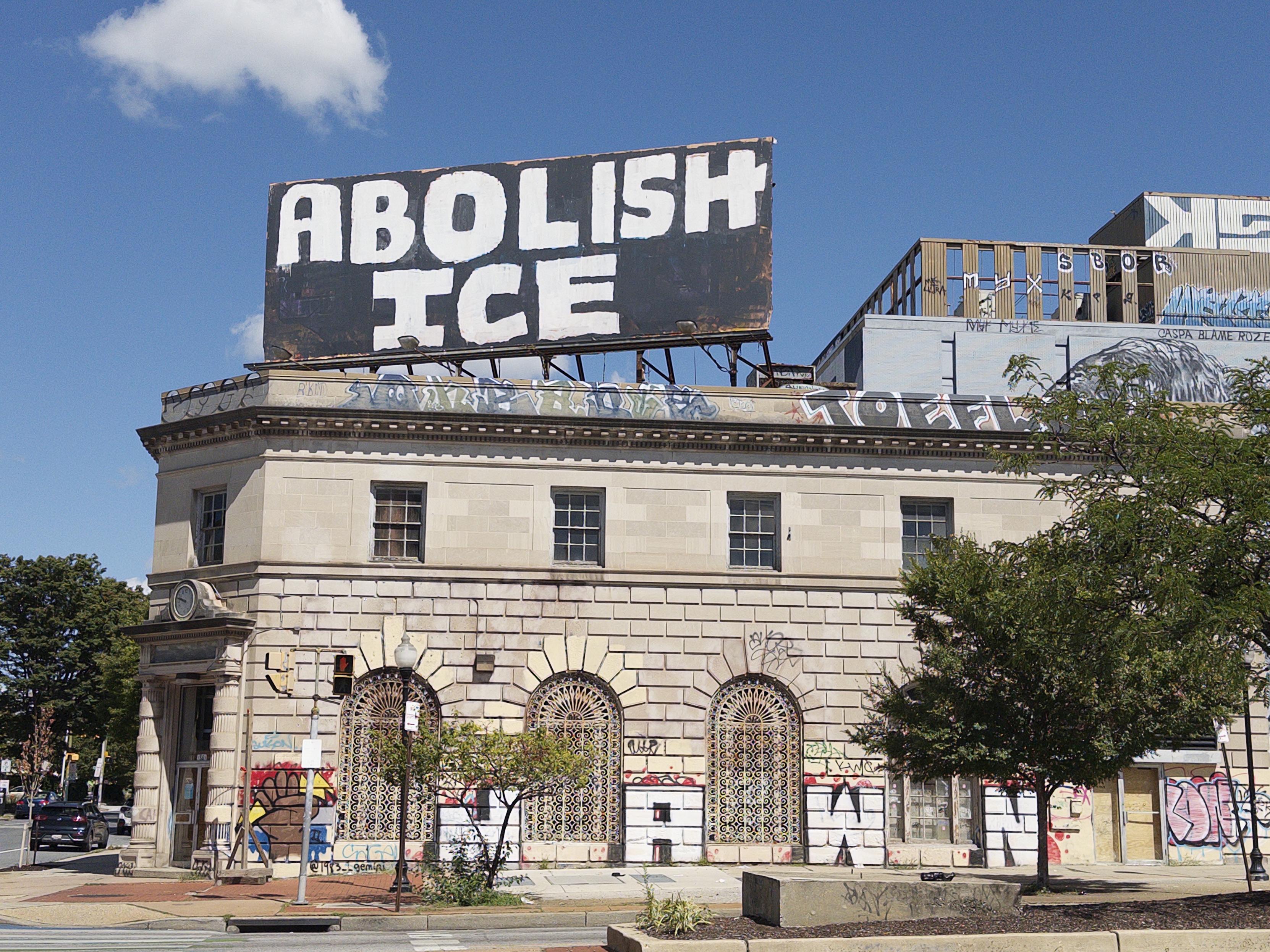 A billboard in Baltimore, handpainted, reading ABOLISH ICE.