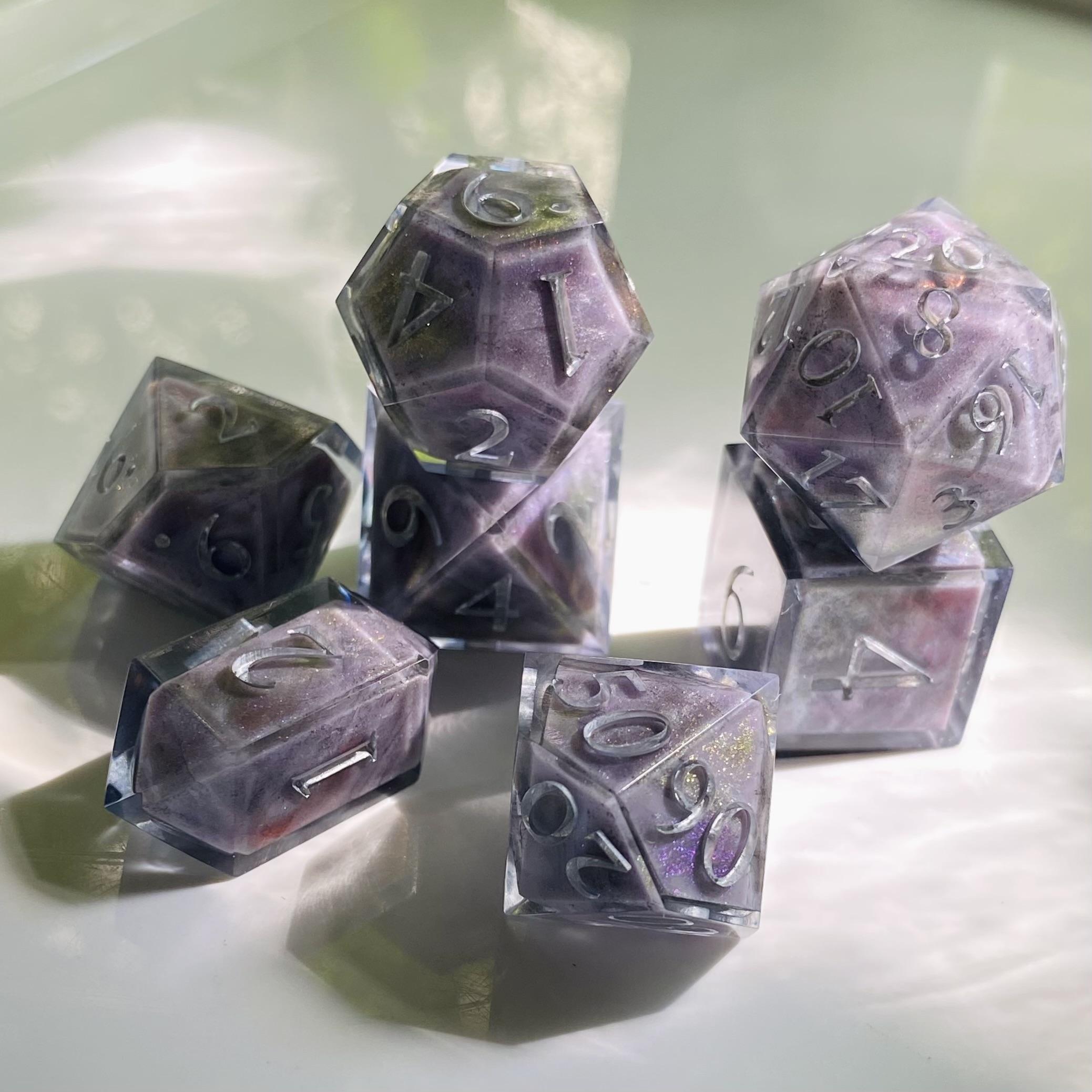 Another seven piece gaming set, these ones look like grey-lavender stones streaked with black, that shimmer with blue, gold, and purple. Like moonstones, but not quite. Numbers in silver
