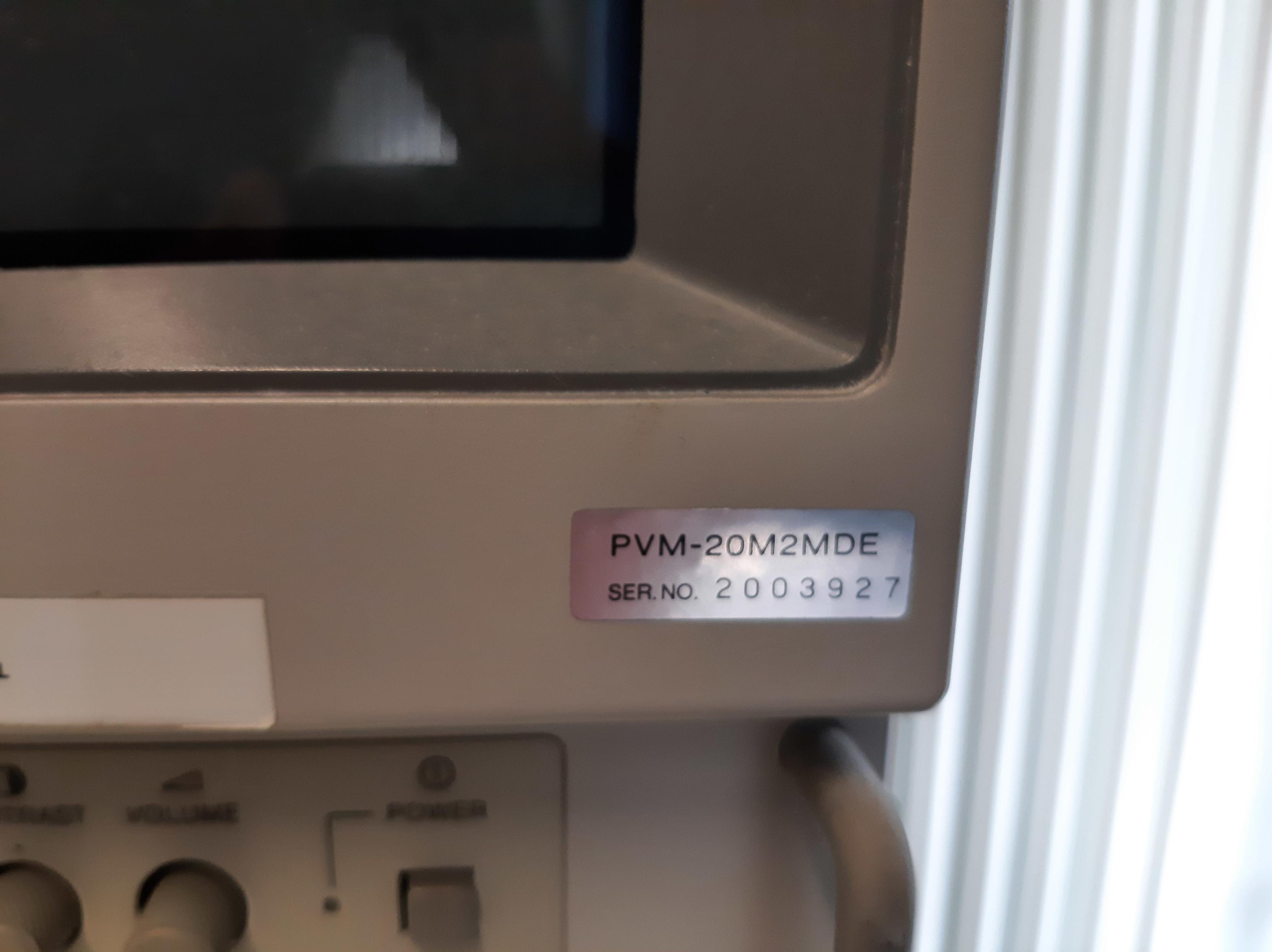 Lower right corner of the monitor, a model number and serial number sticker is visible.