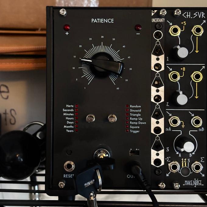 A eurorack synthesizer module with a large black knob, and buttons for switching between different shapes and lengths of time. A safety lock is at the bottom of the module