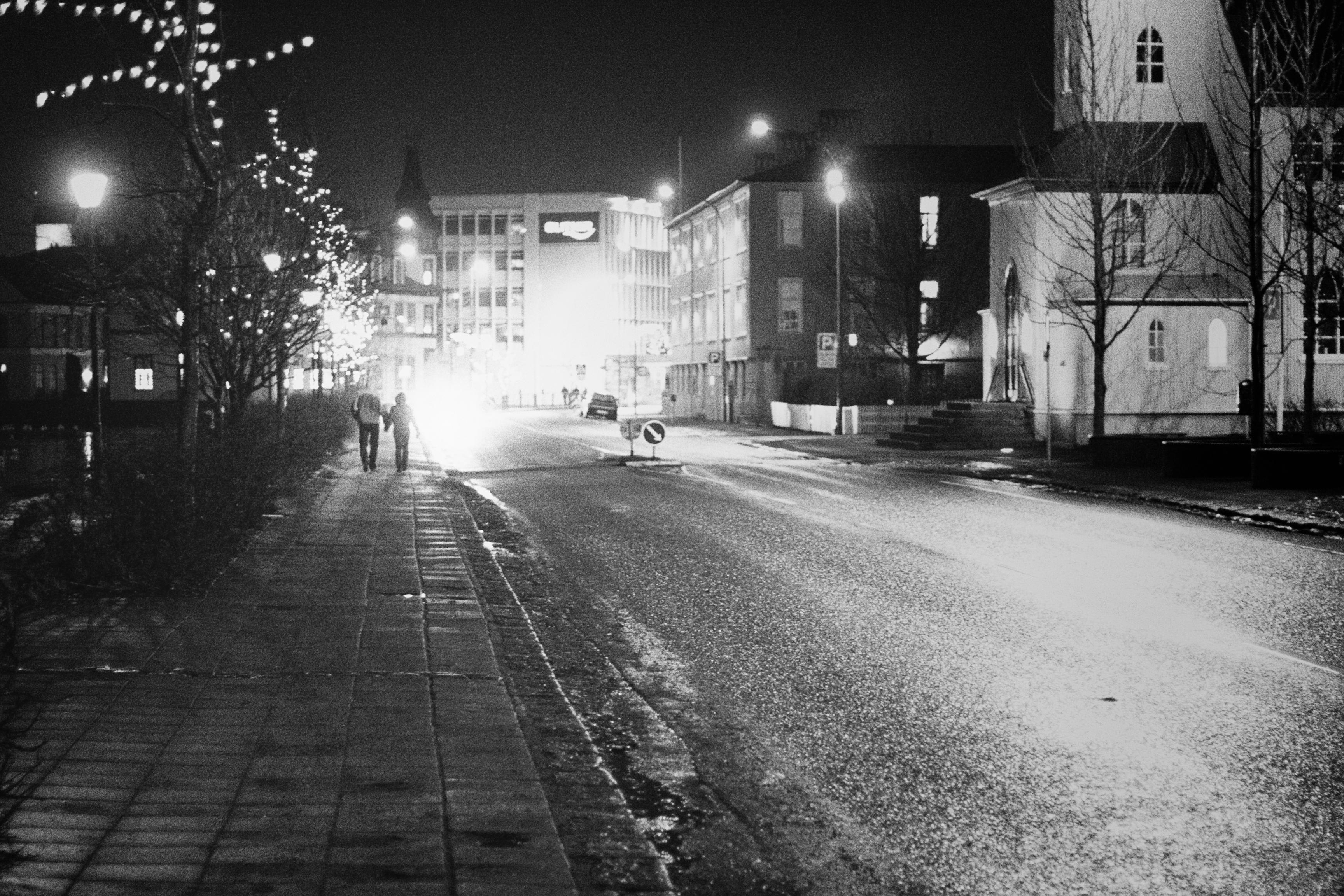A couple walks past the Reykjavík Pond during New Year's Eve.