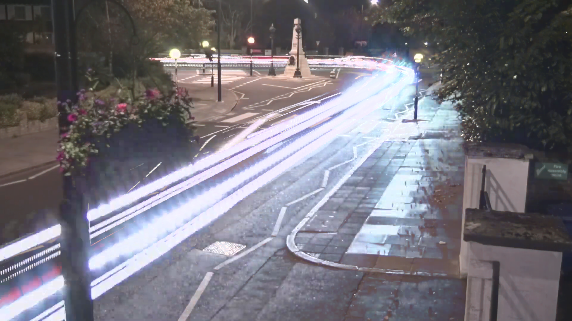 nighttime "photo" of the famous Abbey Road crossing in London, with a headlight trail streaking through
