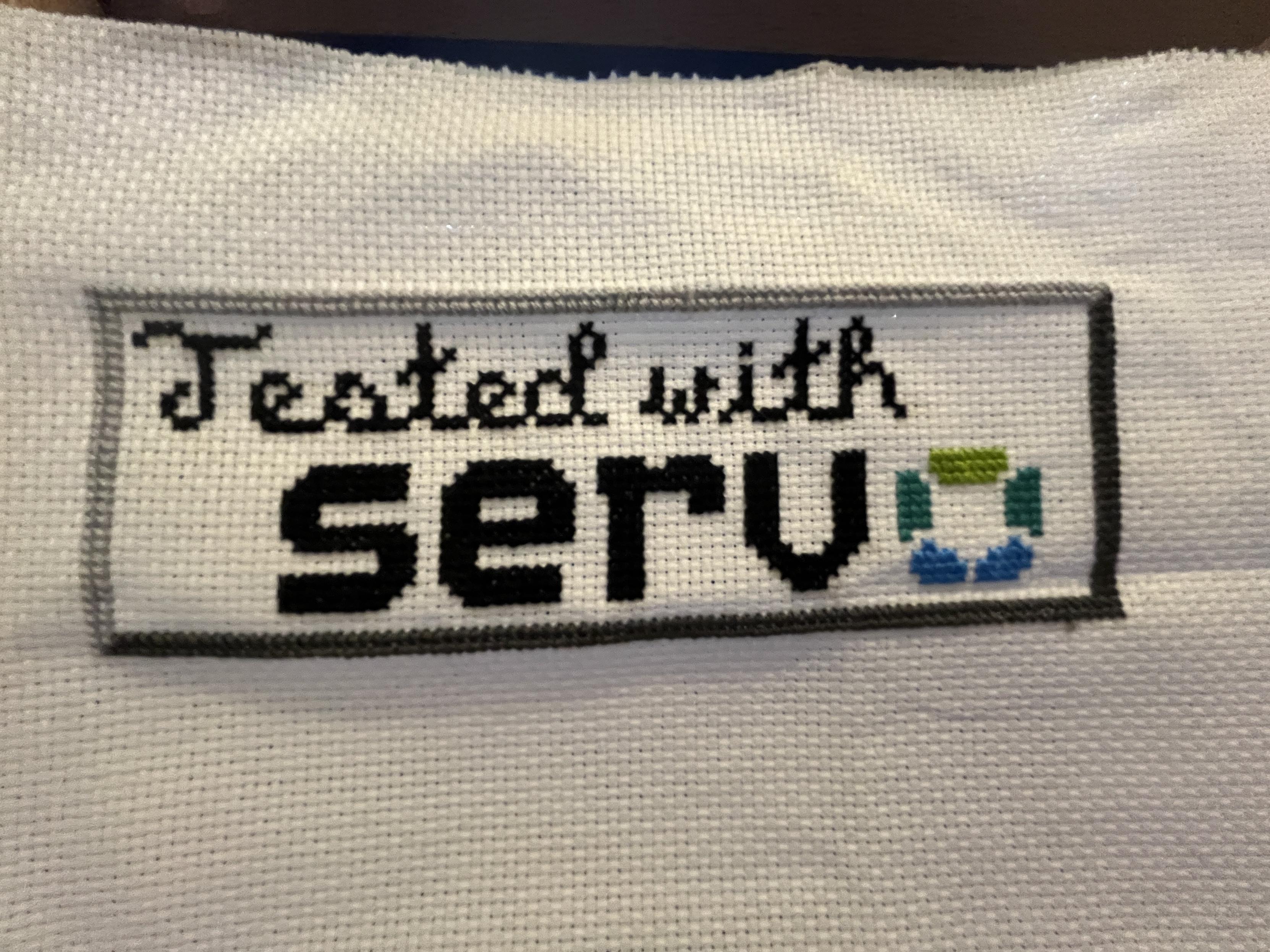 I cross-stitched the banner in white Aida cloth. It’s almost pixel-perfect and the error(s?) aren’t very noticeable. It hasn’t been cut out or had the edges finished but it is otherwise complete and has a couple of big hoop wrinkles on it.