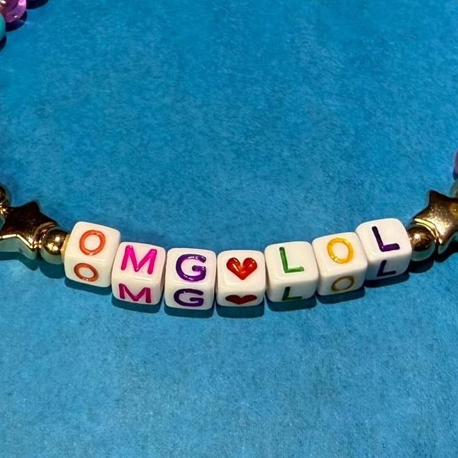 A friendship bracelet that says omg.lol on it