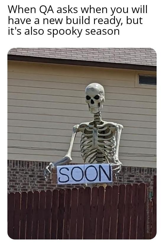 Photo of a large skeleton peering over a fence and holding a sign that reads SOON Caption: When QA asks when you will have a new build ready, but it's also spo…