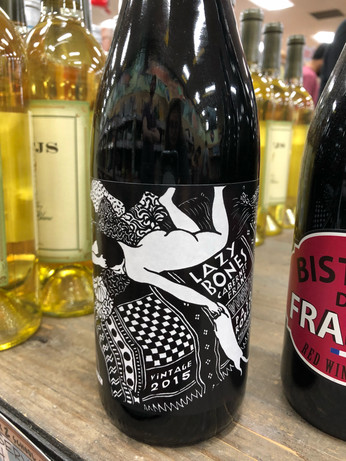 a wine bottle with an image of a naked woman lying face down on a pile of pillows