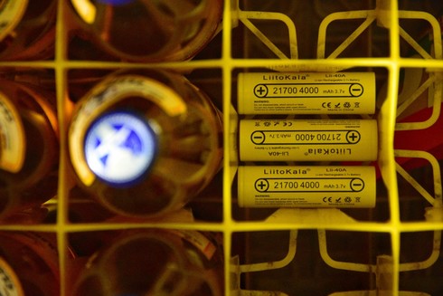 Three of 21700 sized lithium ion battery cells in a club mate crate, right next to each other. 
