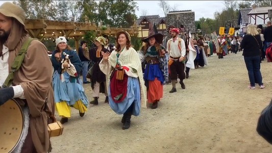 a parade of renaissance dressed people passes