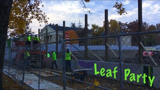 workers in neon green put up a plywood wall
