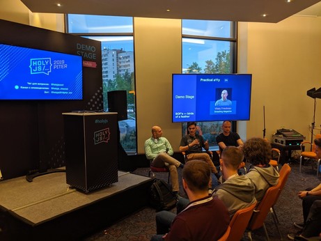 Discussion panel with many people listen closely to Arkadiy, Mauricio and Vitaly 