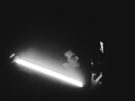 a man with a video camera next to an LED light