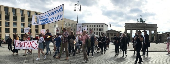 Ein Protestzug mit Schildern und Bannern, z.B. "Russland ohne Putin". Im Hintergrund das Brandenburger Tor.