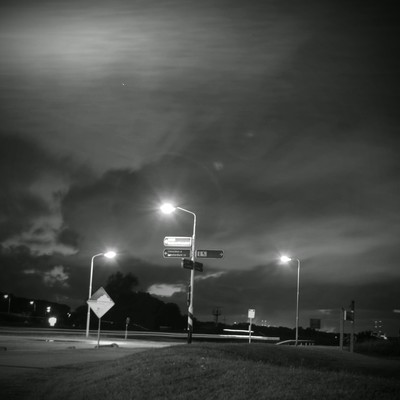 A black and white photograph of road signs and lamp posts near my childhood home.