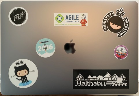 Note book lid with stickers of BoosterConf, Agile Testing Days, GitHub, Inktober, Ministry of Testing, Haithabu and IT Depends