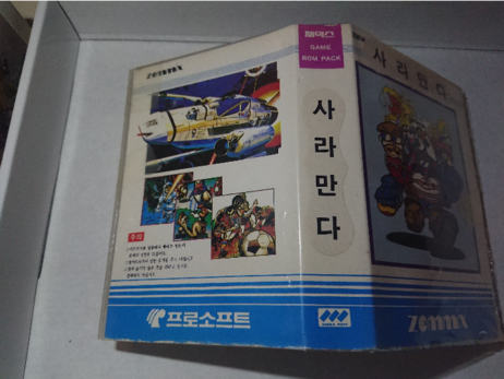 box nr 1, Zemmix MSX cart.
A generic box with the Zemmix logo, Game ROM Pack label, various cartoon game characters and space ships, and a game-specific title label with Korean glyphs on the spine and front.