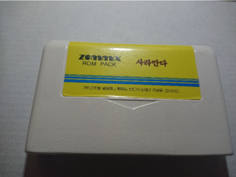 Zemmix "ROM Pack" MSX cart nr 1, which (based on the glyphs) belongs to box nr 1.
A white cartridge with plain yellow label with blue cosmetic stripes, and title in red Korean glyphs.