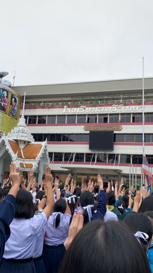今天是星期一，泰国女校的学生们在升旗仪式上高举表示反专制的三指手势。