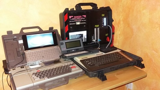 4 old computers on an otherwise lonely desk. Epson HX-20, Atari 800XL, Sony Vaio laptop, Atari Portfolio. 