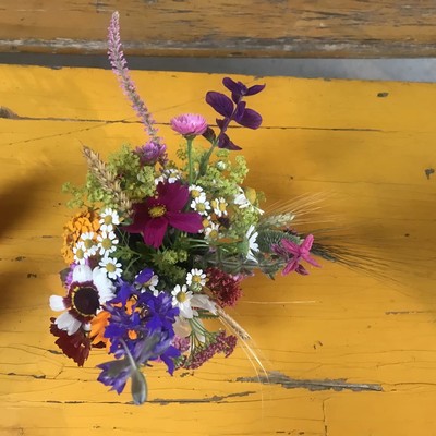 Ein bunter Blumenstrauß auf einem Tisch, von oben fotografiert