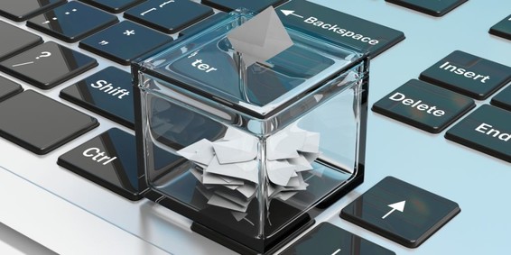 Fotomontage: Miniatur-Wahlurne auf einer Computertastatur
