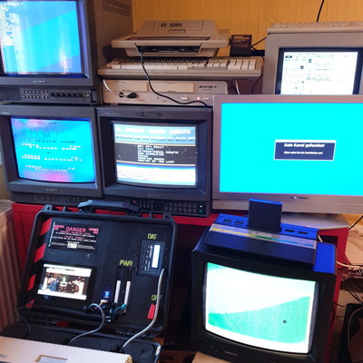 Several hone computers, everal monitors: three Sony Trinitron, a SM124, a normal TV, a flat TV, and the portable Atari.
