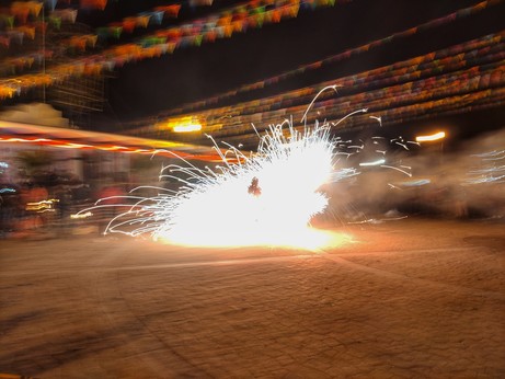 Persona bailando de noche con un torito en un pueblo mexicano.