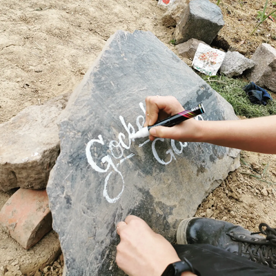 Ein Stein wird mit "Gockel Garten" beschriftet.