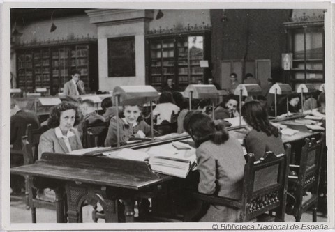 Grupo de mujeres leyendo y escribiendo en una mesa de la sala de lectura de la Biblioteca Nacional de España en los años 30.